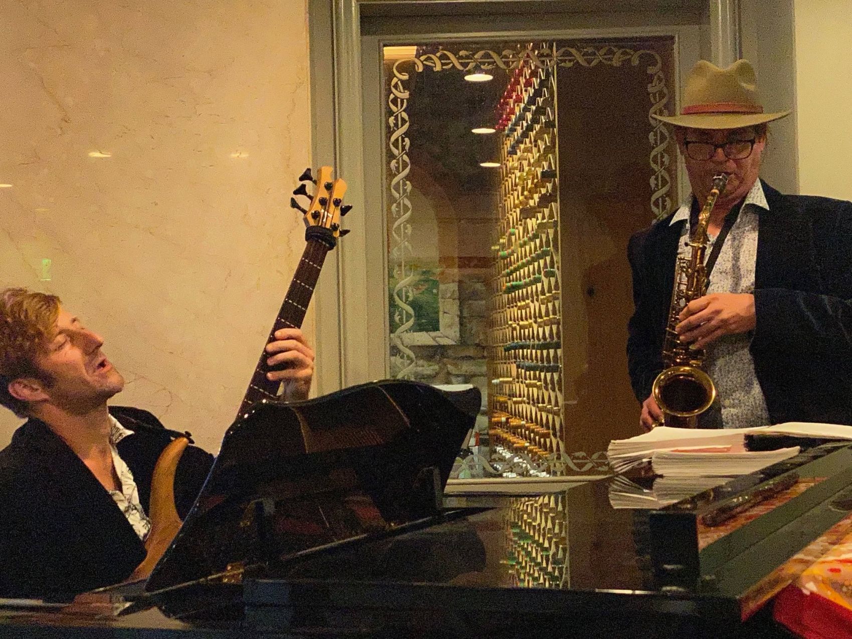 Dan in a hat, saxophone by the wine wall